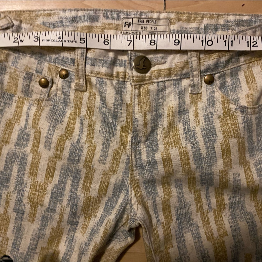Free peoplee low to mid rise ankle jeans with blue and yellow symbols. Sz25